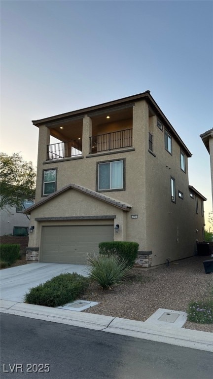 view of front of property featuring a garage and a balcony