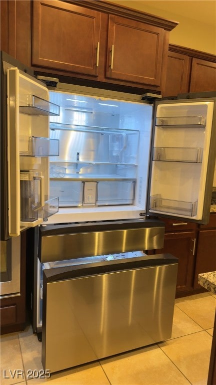 interior details with stone counters and stainless steel refrigerator