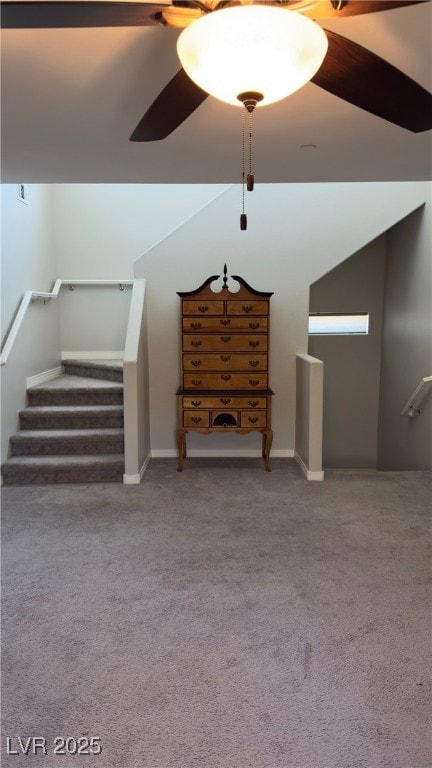 interior space featuring ceiling fan, vaulted ceiling, and carpet