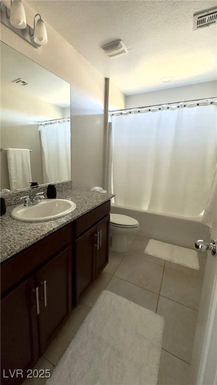 full bathroom with toilet, a textured ceiling, vanity, shower / bath combo with shower curtain, and tile patterned flooring