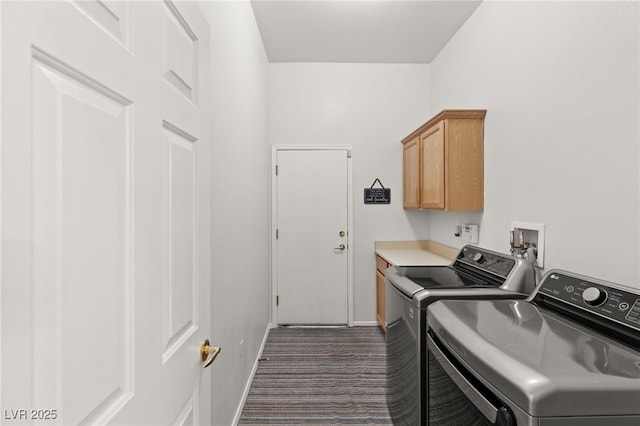 washroom featuring cabinets, washing machine and clothes dryer, and dark colored carpet