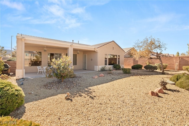 rear view of property featuring ceiling fan and a patio area