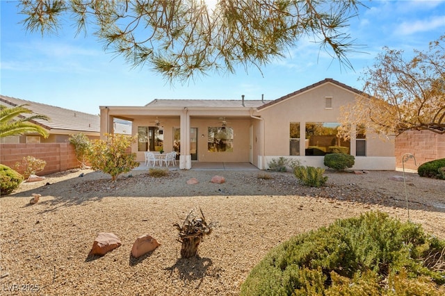 back of property with ceiling fan and a patio area