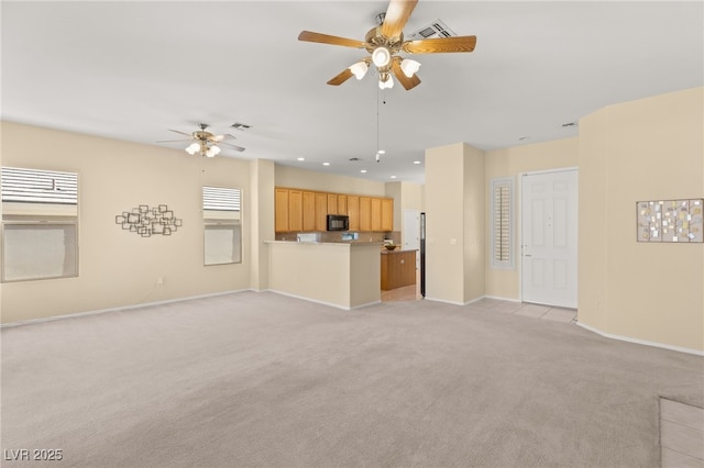 unfurnished living room featuring light colored carpet and ceiling fan