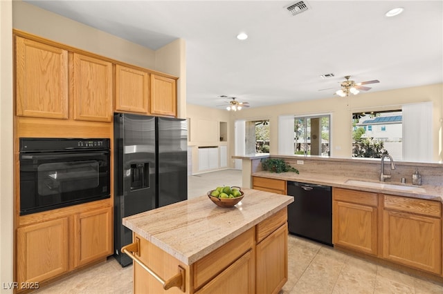 kitchen featuring sink, plenty of natural light, black appliances, and a kitchen island