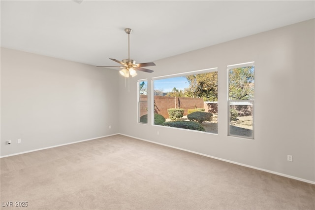 spare room featuring light colored carpet and ceiling fan