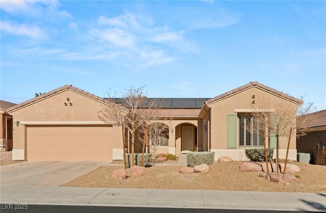 ranch-style house featuring a garage and solar panels