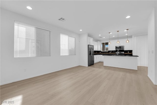 2033 Old Field Ave, North Las Vegas, NV 89081 - kitchen featuring stainless steel microwave, fridge with ice dispenser, dark countertops, open floor plan, and white cabinets