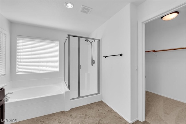 2033 Old Field Ave, North Las Vegas, NV 89081 - bathroom featuring a shower stall, a garden tub, a walk in closet, and baseboards