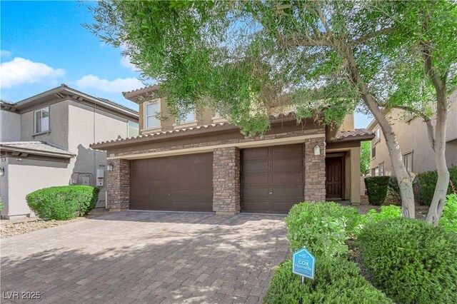 2033 Old Field Ave, North Las Vegas, NV 89081 - mediterranean / spanish house featuring stucco siding, a tile roof, an attached garage, decorative driveway, and stone siding