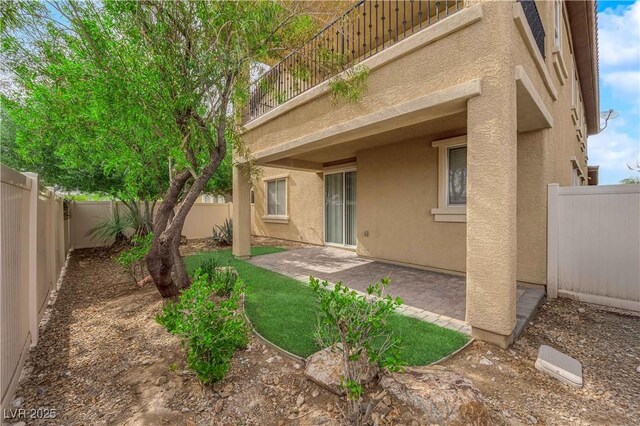 2033 Old Field Ave, North Las Vegas, NV 89081 - rear view of house featuring stucco siding, a balcony, a patio area, and a fenced backyard