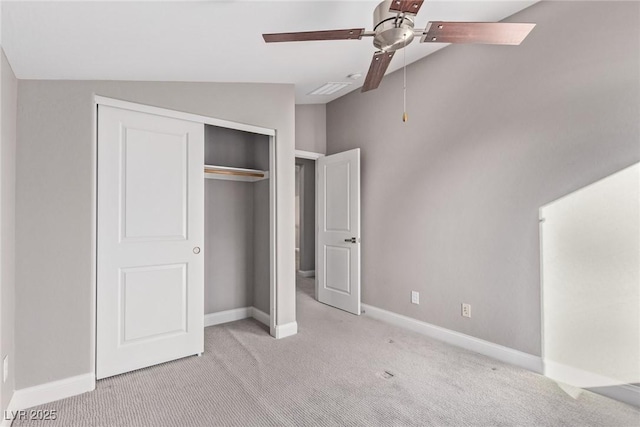 unfurnished bedroom with vaulted ceiling, light carpet, ceiling fan, and a closet