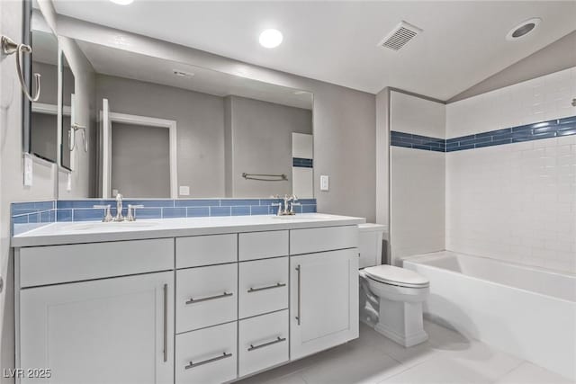 full bathroom featuring toilet, vaulted ceiling, vanity, tiled shower / bath combo, and tile patterned flooring