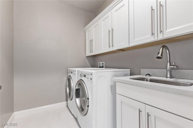 washroom featuring separate washer and dryer, sink, light tile patterned floors, and cabinets