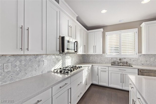 kitchen with white cabinetry, sink, tasteful backsplash, and stainless steel appliances