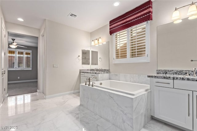 bathroom with a relaxing tiled tub, ceiling fan, and vanity