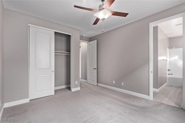 unfurnished bedroom with connected bathroom, light colored carpet, ceiling fan, and a closet