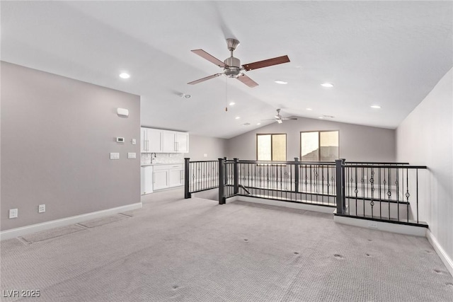 spare room with vaulted ceiling and light colored carpet