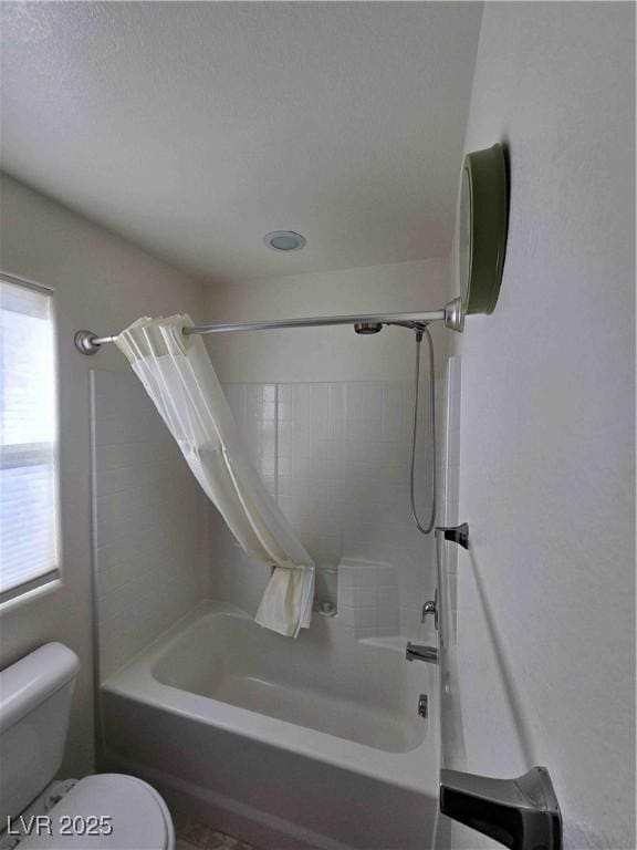 bathroom with shower / tub combo with curtain and toilet