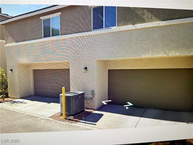 view of front of home featuring a garage and central AC