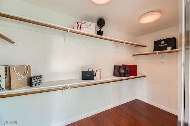 walk in closet with dark wood-type flooring