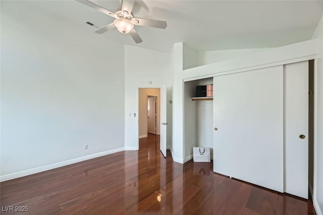 unfurnished bedroom with ceiling fan, dark hardwood / wood-style floors, vaulted ceiling, and a closet