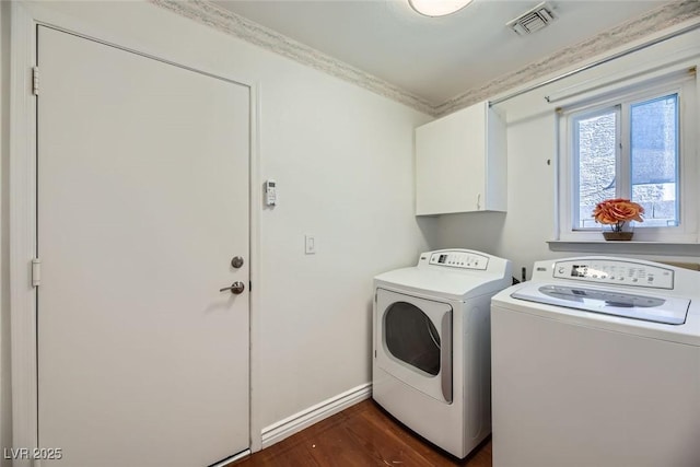 washroom featuring crown molding, cabinets, dark hardwood / wood-style floors, and washer and dryer