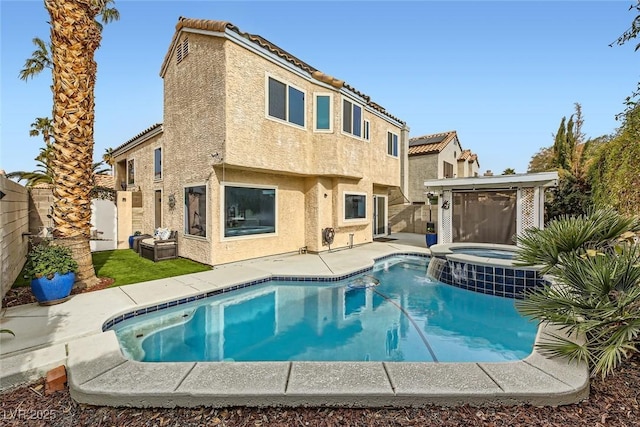 back of property featuring a pool with hot tub and a patio area