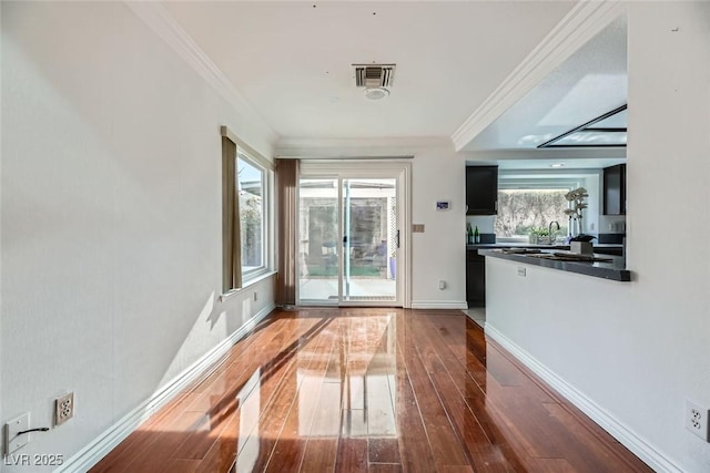 doorway with crown molding, dark hardwood / wood-style floors, and sink