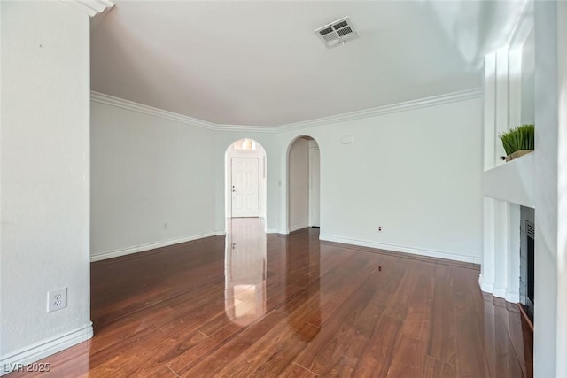 unfurnished living room featuring crown molding and dark hardwood / wood-style flooring