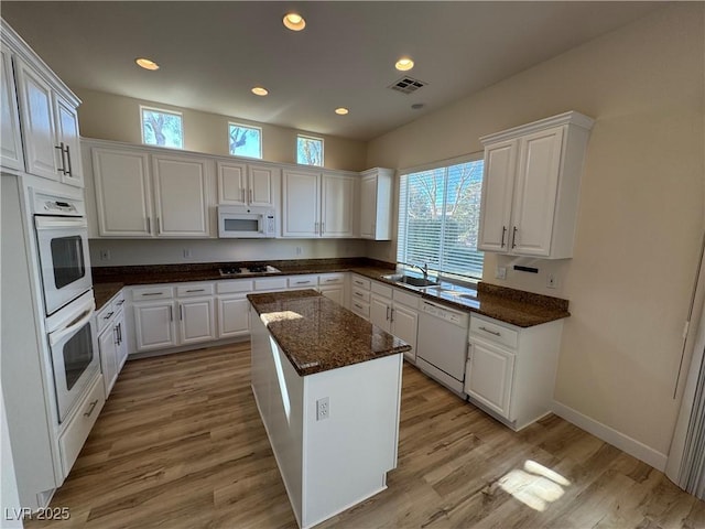 kitchen featuring white cabinetry, white appliances, and a kitchen island