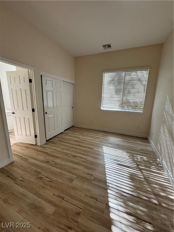 unfurnished bedroom with hardwood / wood-style flooring and a closet