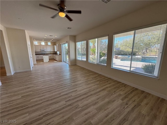 unfurnished living room featuring hardwood / wood-style flooring and ceiling fan