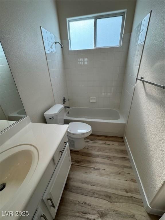 full bathroom with wood-type flooring, toilet, vanity, and tiled shower / bath