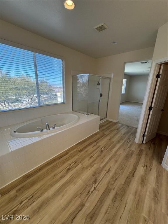 bathroom with hardwood / wood-style floors and plus walk in shower