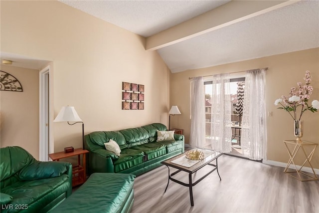 living room featuring vaulted ceiling with beams, a textured ceiling, baseboards, and wood finished floors