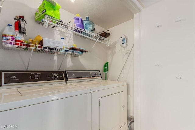 clothes washing area with washing machine and dryer