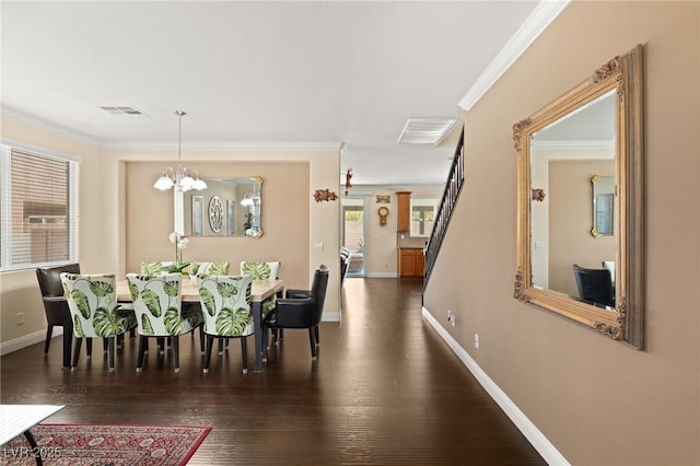 dining room with dark hardwood / wood-style flooring, crown molding, and a chandelier