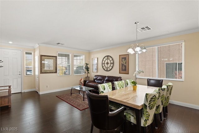 dining area with an inviting chandelier, crown molding, and dark wood-type flooring