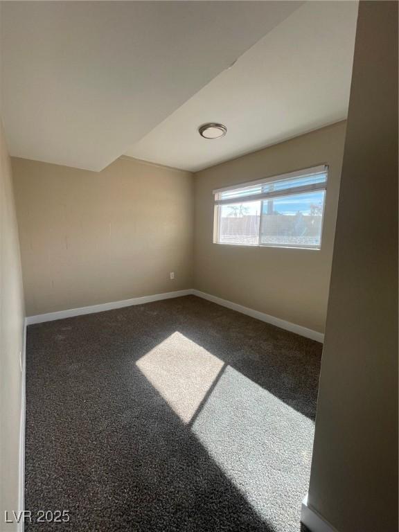 spare room featuring dark carpet