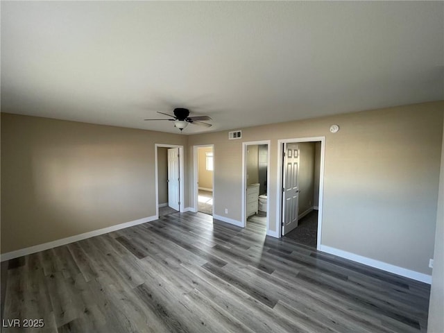 empty room featuring dark wood-type flooring and ceiling fan