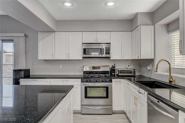 kitchen featuring sink, stainless steel appliances, and white cabinets