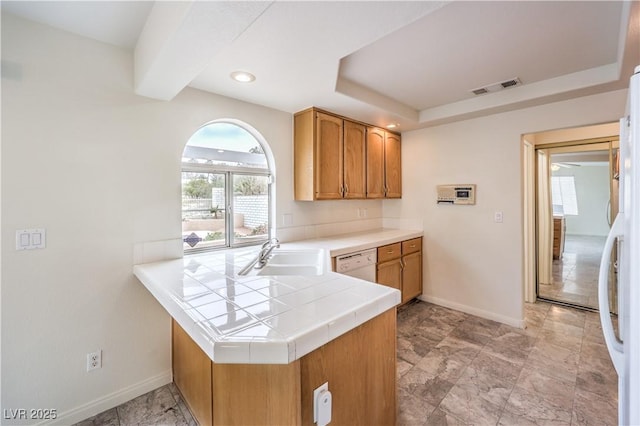 kitchen with sink, white appliances, tile countertops, and kitchen peninsula