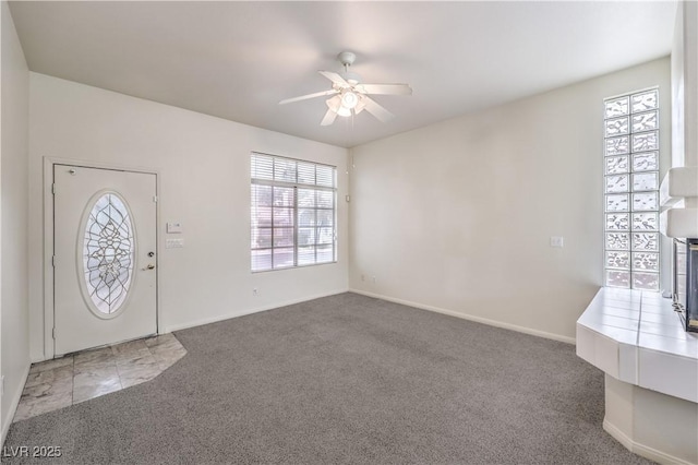 carpeted entryway with ceiling fan