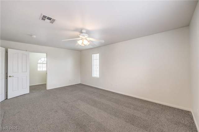 spare room featuring ceiling fan, carpet, and a wealth of natural light