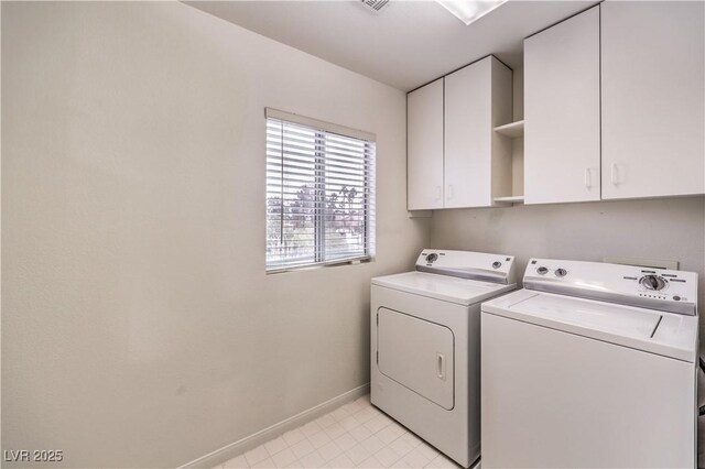 washroom featuring washing machine and dryer and cabinets