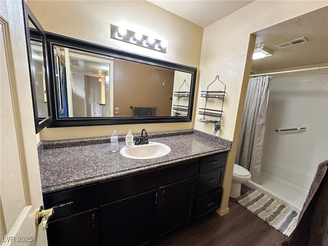 bathroom with wood-type flooring, curtained shower, vanity, and toilet