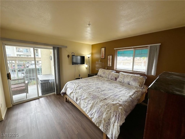 bedroom featuring access to exterior, wood-type flooring, and a textured ceiling