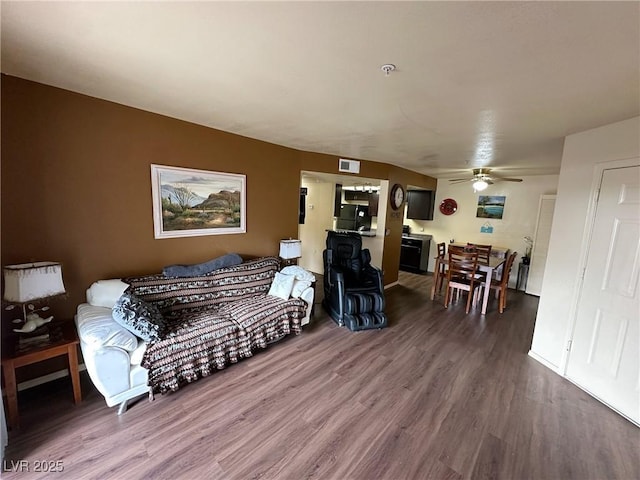 living room featuring wood-type flooring and ceiling fan