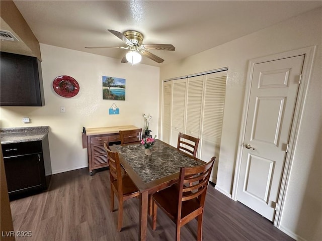 dining room with dark wood-type flooring and ceiling fan